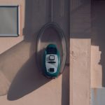 Ticket validator mounted on a wall in Avola, Sicily, casting a shadow in the afternoon light.
