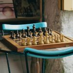 Intellectual Property Strategy: Building Lasting Market Moats Chessboard with pieces set for play on a wooden table in a cozy rustic indoor setting.