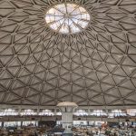 Interplanetary Trade: Building Legal Frameworks for Space View of a geometric dome ceiling over a bustling indoor market space.