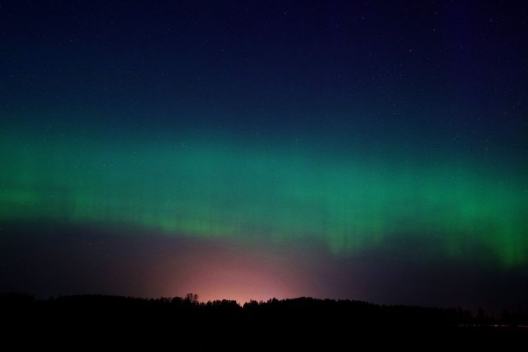 A mesmerizing display of the Aurora Borealis in the night sky over Ventspils, Latvia.
