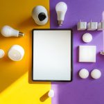 IoT Strategy: Transforming Data into Operational Excellence Top view of smart home devices and tablet on split yellow and purple background.