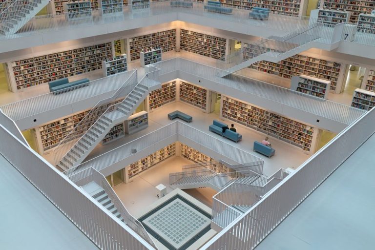 Explore the airy and geometric space of a modern library with intricate staircases and minimalist design.