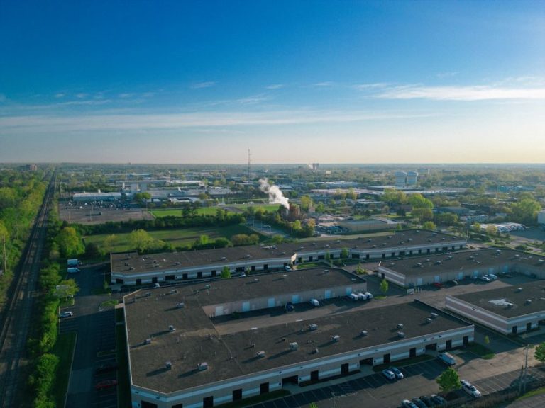 Expansive aerial view of an industrial area showcasing buildings, roads, and green spaces.