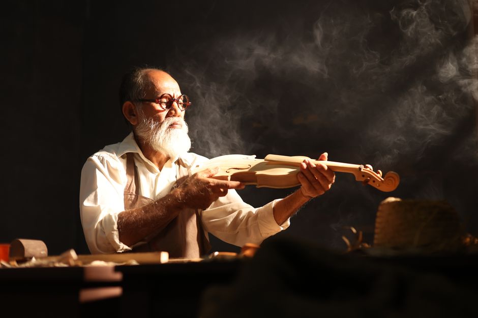 A skilled luthier crafts a violin, highlighting traditional woodworking in Jakarta, Indonesia.