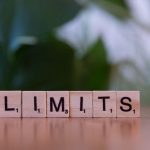 Moore's Law Limits: Atomic-Scale Fabrication & Tech Strategy Wooden letter tiles forming the word 'LIMITS' on a wooden table.