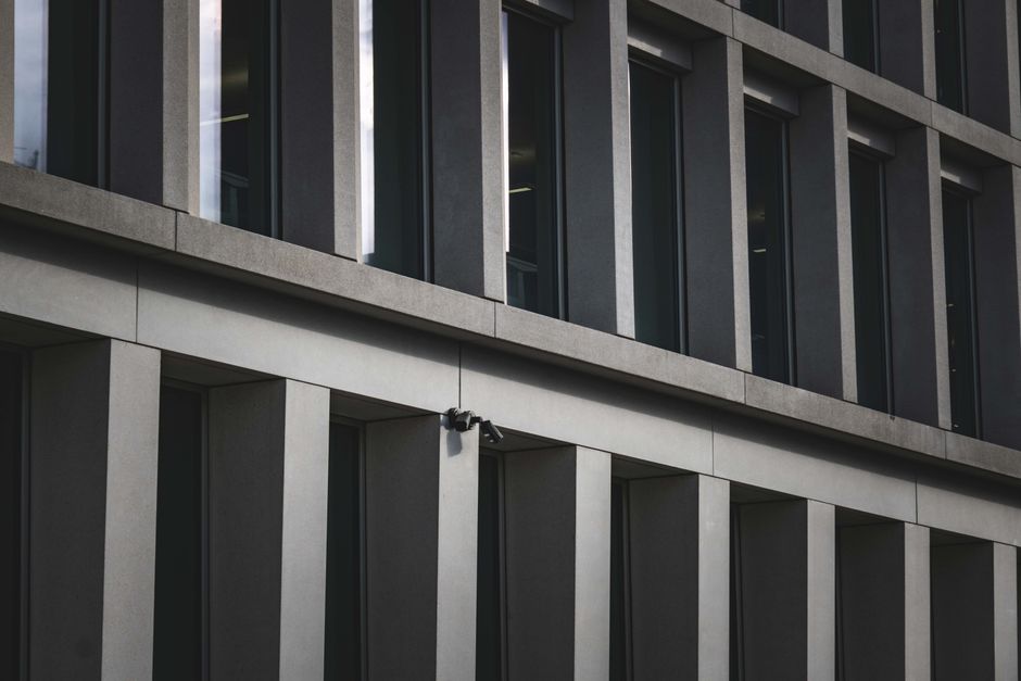 Contemporary office building exterior featuring multiple windows and security cameras.
