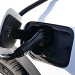 Next-Gen Battery Strategy: Solid-State and Silicon Tech Trends Close-up view of an electric vehicle charging with a focus on the connector and charging port.