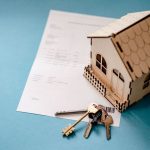 <title>Ocean House: A Masterclass in Operational Consistency</title> Miniature wooden house with keys and contract symbolizing real estate transactions.