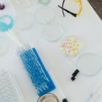 Open-Source Drug Discovery: A New Strategy for Pharma Leaders Aerial view of laboratory equipment including petri dishes, pills, test tubes, and syringes.