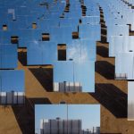 Operational Excellence: Terraforming Strategy for Business Aerial shot of reflective solar panels in the desert showcasing renewable energy.