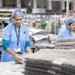 Focused textile factory workers organizing materials efficiently indoors.