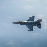 Military F-16 jet flying against a backdrop of clouds, showcasing aviation power.