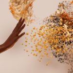 Creative concept depicting a hand reaching towards abstract swirling particles.