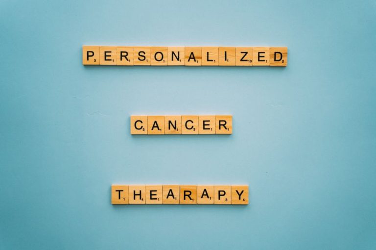 Conceptual image with Scrabble tiles on a blue background spelling 'Personalized Cancer Therapy'.