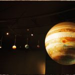 Scale models of solar system planets in a planetarium exhibit.