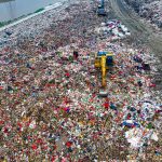Plastic Degradation: The Operational Strategy for Circularity Birds-eye view of a bustling landfill in Banten with excavators working amidst the piles of waste.