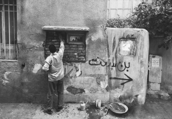 A candid urban street scene in Tehran, capturing daily life in monochrome.