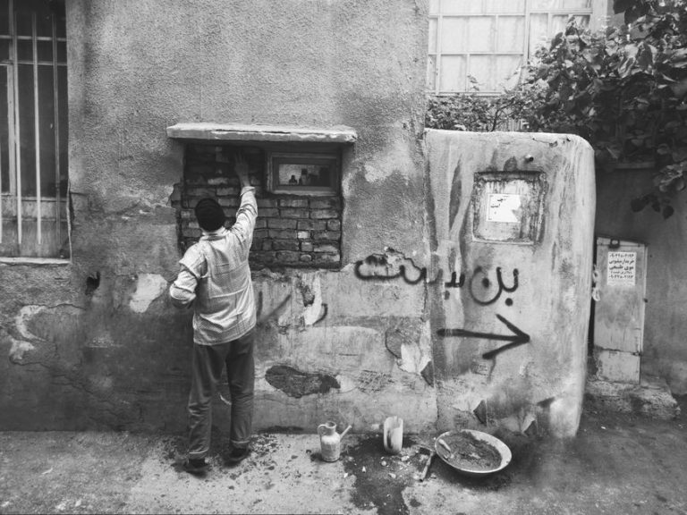 A candid urban street scene in Tehran, capturing daily life in monochrome.