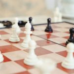 A detailed close-up of a chess game in progress with focus on the pieces.
