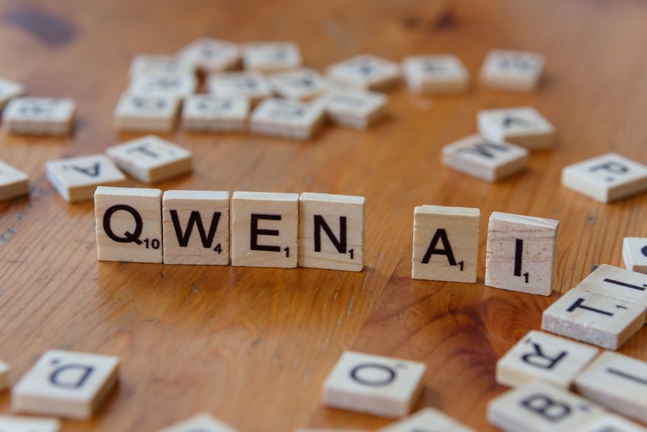Scrabble-like tiles arranged to spell 'Qwen AI' on a wooden surface, depicting technology concepts.