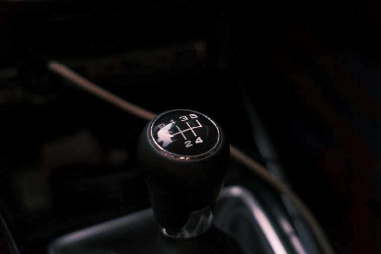 Detailed view of a car's manual transmission shift knob with visible gear pattern.