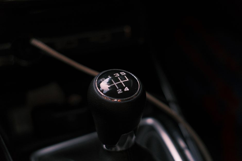 Detailed view of a car's manual transmission shift knob with visible gear pattern.