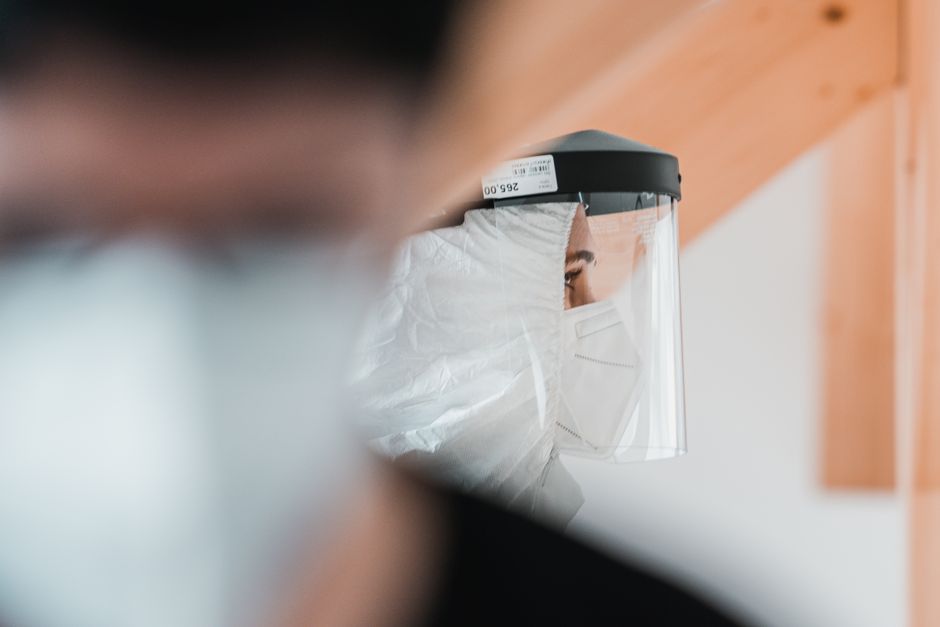 Close-up of a healthcare worker in a protective suit and face shield, emphasizing safety during the pandemic.