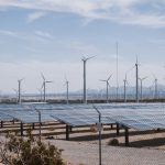 Renewable Energy Integration: A Guide to Operational Strategy A renewable energy farm with wind turbines and solar panels under a clear sky.