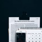 Semantic Indexing: The New Competitive Frontier for Business Digital currencies article with smartphone stock market app and calendar on black surface.