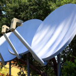 Satellite dishes in nature setting, emphasizing technology blend with environment.