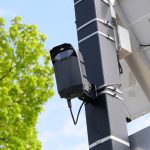 Smart Infrastructure Sensors: Predictive Strategy for Business A modern surveillance camera powered by solar energy mounted on a street pole.