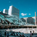 Vibrant urban square with modern art installations and people enjoying a sunny day.