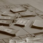 Social Investment Strategy: Building Institutional Durability Close-up of board game with play money in sepia tone, focusing on strategic play.
