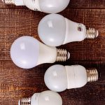 Solid-State Lighting: A Strategic Imperative for Operations Collection of LED light bulbs arranged on a rustic wooden background.