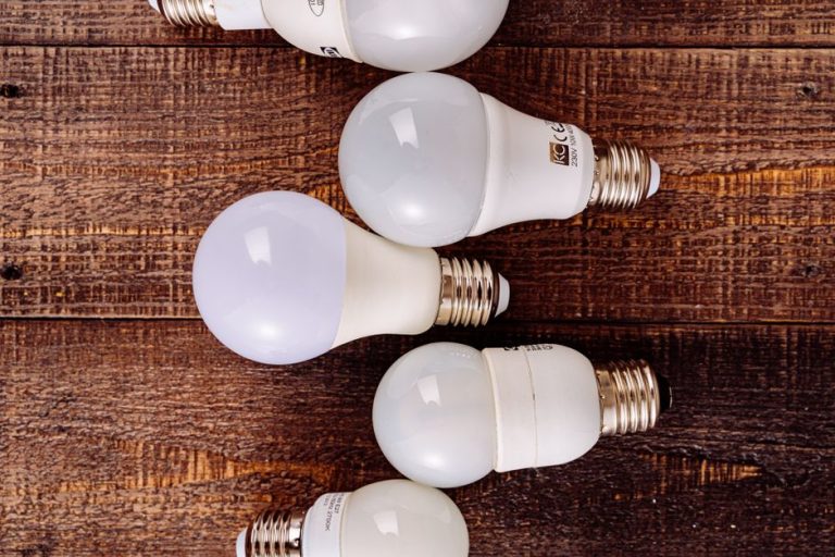 Collection of LED light bulbs arranged on a rustic wooden background.