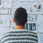 Solving the Privacy-Execution Paradox: Secure Data Strategies A man stands in front of a wall filled with creative ideas and plans. Ideal for innovation themes.