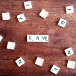 Space Law and Strategy: Mastering Operations in the Void Scrabble tiles spelling 'LAW' on a wooden table, symbolizing connections to education and legality.