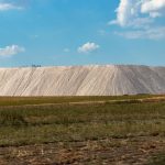 Space Mining Laws: Navigating Regulatory Risks for Executives Expansive salt mine landscape with clear blue sky, capturing natural industry outdoors.