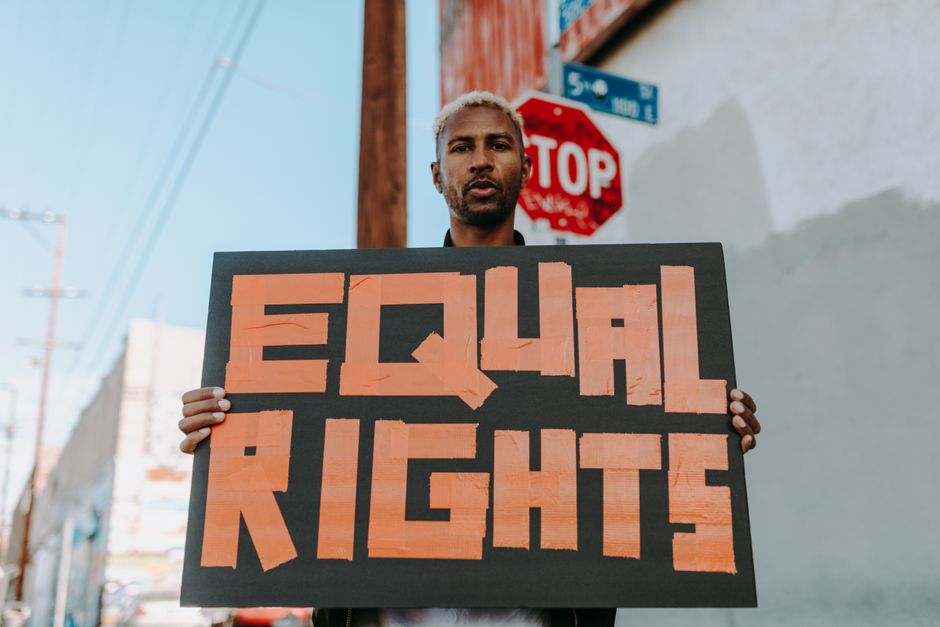A person holding an 'Equal Rights' sign during a peaceful protest on the street.