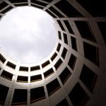 Strategic Architecture of Open Source for Business Growth Low angle shot of a circular modern building interior with skylight and geometric design.