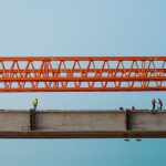 Workers and red crane on a bridge construction in Chilmari, Bangladesh.