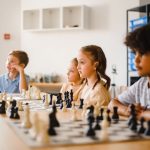 Kids focused on an intense chess game in a classroom, promoting strategic thinking.