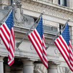 Strategic Patriotism: Building Organizational Identity for Success Three American flags hanging on a historic Boston building façade, symbolizing patriotism.