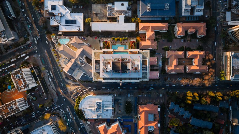 Stunning aerial shot of Sandton's urban landscape showcasing modern architecture, roads, and rooftop pools.
