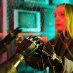Synthetic Empathy: Scaling Leadership with AI and Data A woman interacts with robotic hands through a mesh displaying a neon cyberpunk atmosphere.
