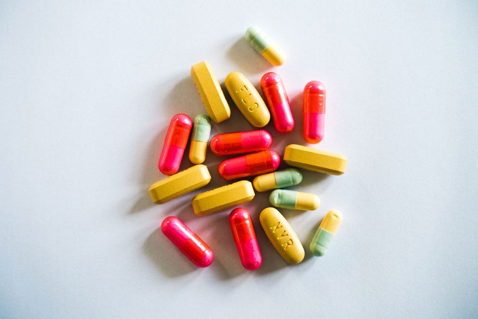 A vibrant assortment of various pills and capsules on a light background, showcasing pharmaceutical diversity.