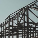Modern steel framework structure under clear sky, showcasing architectural design.