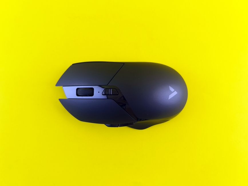 A sleek black gaming mouse rests on a bright yellow background, emphasizing contrast and design.