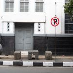 Historic colonial architecture in Bandung, Indonesia with no parking sign in front.
