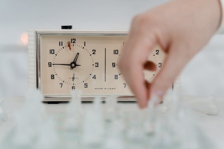 Focus on a chess clock and player's hand moving a piece, capturing the intensity of the game.